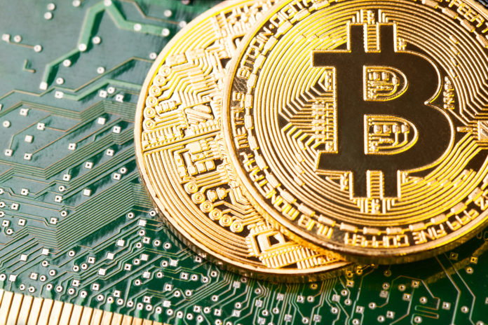 Golden Bitcoin Cryptocurrency on computer circuit board. hedge fund