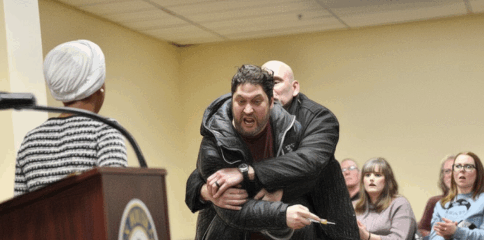 Man charges at Rep. Ilhan Omar and sprays her with substance at town hall Man charges at Rep. Ilhan Omar and sprays her with substance at town hall
