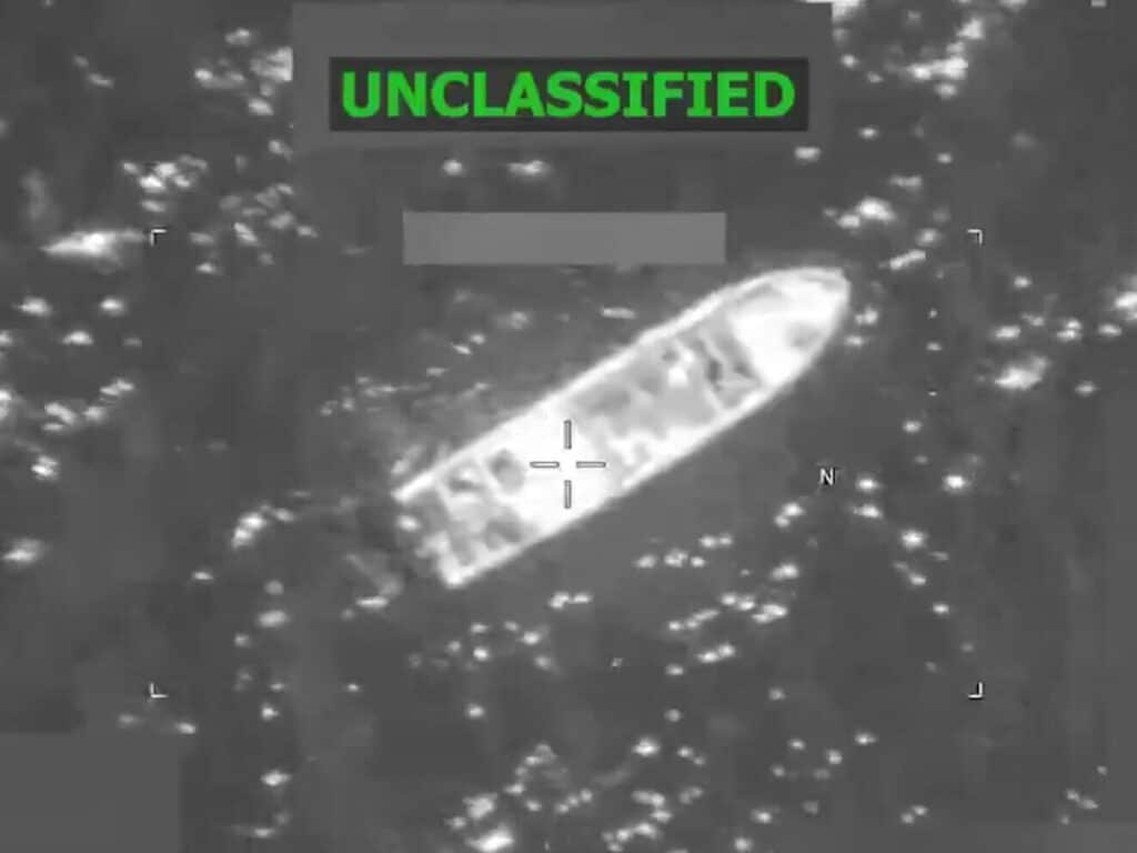 Grayscale surveillance image showing a long boat-shaped object on water with crosshair targeting marks and an ON-CLASSIFIED banner at the top.