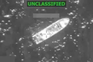 Grayscale surveillance image showing a long boat-shaped object on water with crosshair targeting marks and an ON-CLASSIFIED banner at the top.