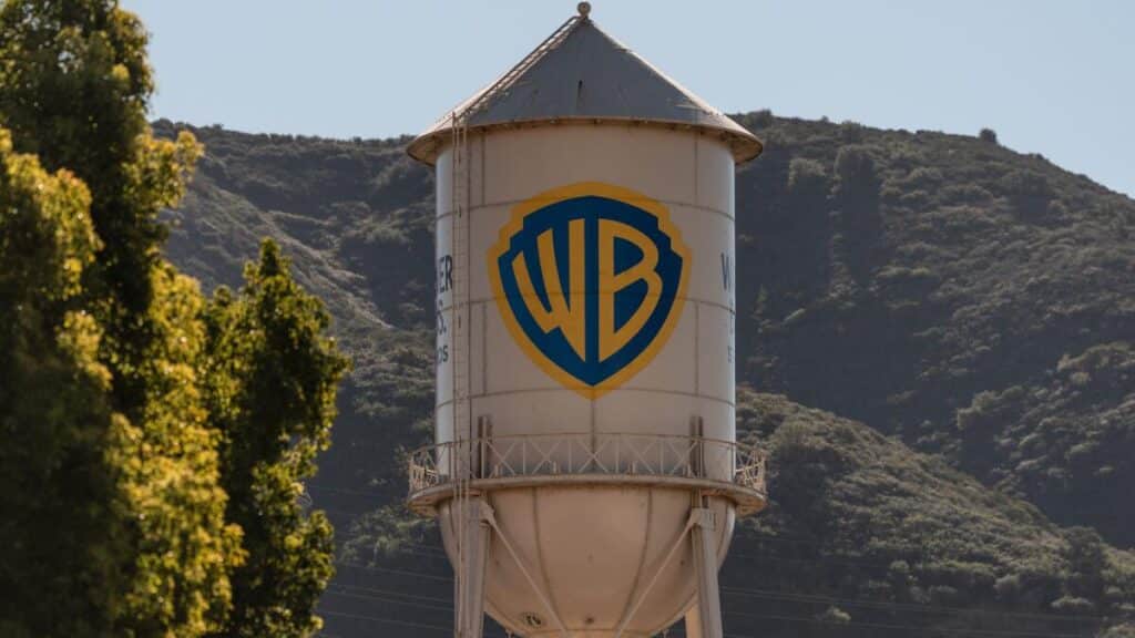 Water tower featuring the Warner Bros logo (WB shield) with trees and hills in the background.