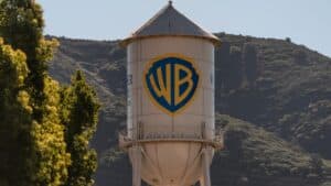 Water tower featuring the Warner Bros logo (WB shield) with trees and hills in the background.