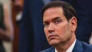 Close-up of a man in a blue suit with a serious expression.