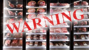 Refrigerated meat display with a bold red WARNING stamp across the glass, signaling caution about meat safety.