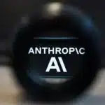 Close-up of a camera lens with the words 'ANTHROPIC AI' visible through the glass.