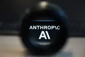 Close-up of a camera lens with the words 'ANTHROPIC AI' visible through the glass.