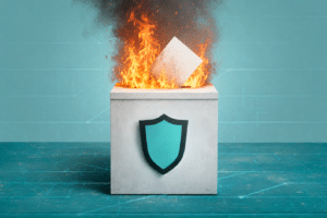 Concrete box with a teal shield emblem; a burning document sits on top, symbolizing secure data destruction or protection.