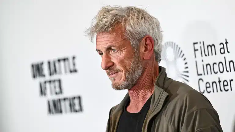 Portrait of a gray-bearded man in a dark shirt and olive jacket, standing at a Film at Lincoln Center event with the logo in the background.