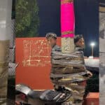 Several men are tied up with duct tape to posts and walls in a dim outdoor area, with motorcycles nearby and a cartoon mouse sticker on the right.
