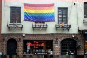 Rainbow Pride flag hangs above The Stonewall Inn on a brick building on a city street