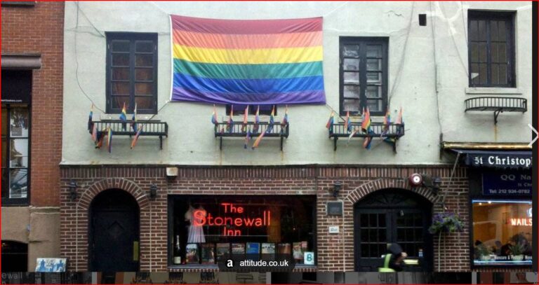 Rainbow Pride flag hangs above The Stonewall Inn on a brick building on a city street