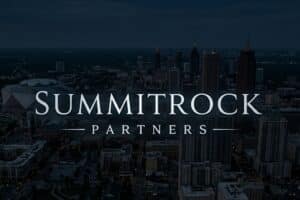 SummitRock Partners logo over a nighttime aerial view of a downtown city skyline