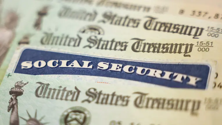 Close-up of a blue Social Security card overlaid on U.S. Treasury documents.
