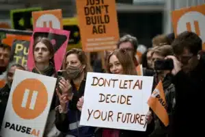 Protesters hold signs urging to pause AI, with a prominent white sign reading Don't Let AI Decide Your Future.