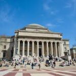 Grand neoclassical museum with tall columns and a domed roof, crowds on the wide front steps.