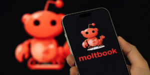 Smartphone screen shows a red cartoon mascot and the word 'moltbook' in red on a dark background, with a larger blurred mascot in the background.