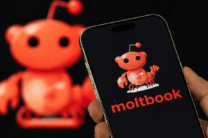 Smartphone screen shows a red cartoon mascot and the word 'moltbook' in red on a dark background, with a larger blurred mascot in the background.