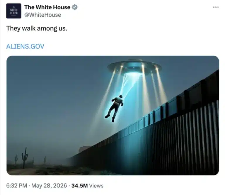 A person is lifted into a glowing blue beam from a hovering saucer above a desert border fence at dusk.