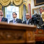 FIFA President Gianni Infantino and former senior adviser Carlos Cordeiro attend a White House World Cup meeting with the tournament trophy nearby.