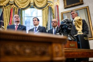 FIFA President Gianni Infantino and former senior adviser Carlos Cordeiro attend a White House World Cup meeting with the tournament trophy nearby.