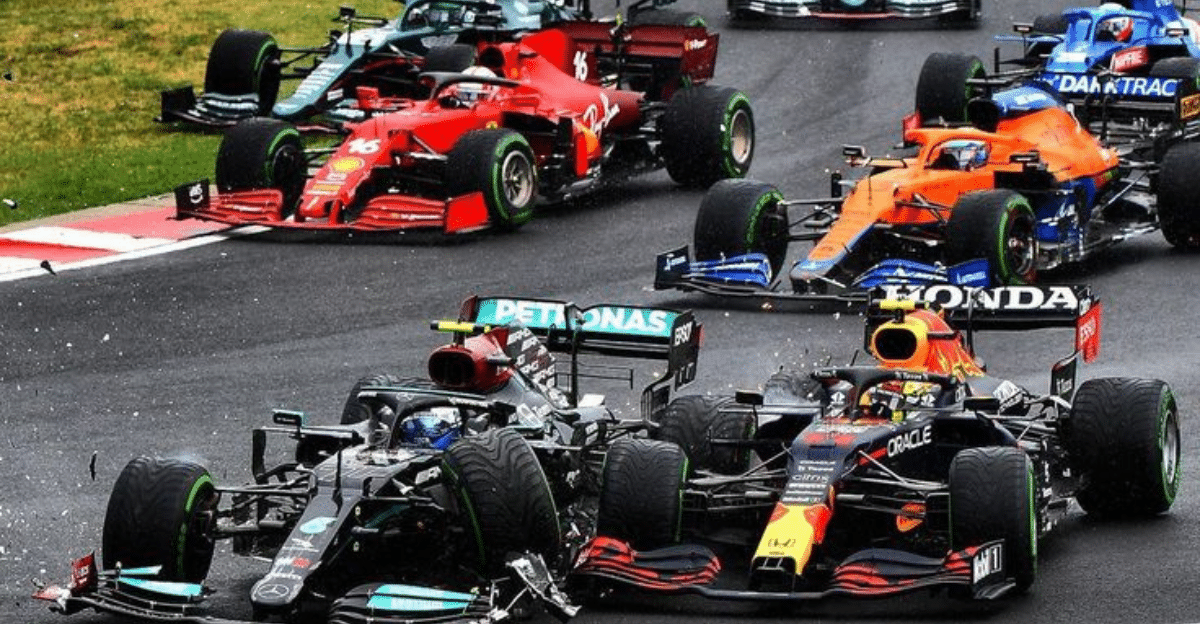 Close-packed Formula 1 cars racing on a track, with a Mercedes in the foreground and red Ferrari, orange McLaren, and blue cars nearby; tire spray visible on wet pavement.