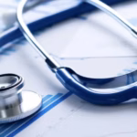 Stethoscope resting on medical charts and graphs, symbolizing healthcare data analysis.