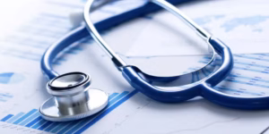Stethoscope resting on medical charts and graphs, symbolizing healthcare data analysis.