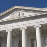 White neoclassical building with six large columns and a triangular pediment reading ‘Hartford Fire Insurance Company’.