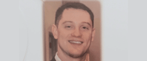 Head-and-shoulders portrait of a smiling man with short dark hair in a suit