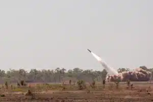 U.S. Army HIMARS launcher firing an ATACMS missile during a military exercise.