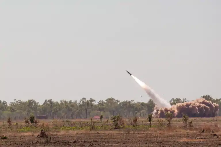 U.S. Army HIMARS launcher firing an ATACMS missile during a military exercise.