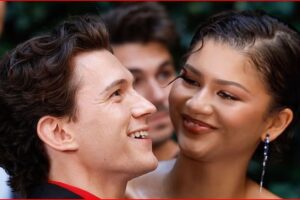 Man and woman smiling at each other in an outdoor setting, close-up portrait.