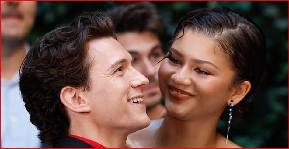 Man and woman smiling at each other in an outdoor setting, close-up portrait.