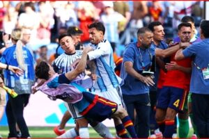 Soccer players and staff involved in a scuffle on the field, grabbing and pushing near the goal area of a match in progress.
