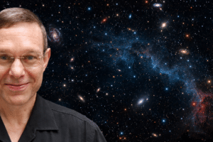 Smiling man in a black shirt against a starry space backdrop with the USA Herald logo in the bottom right.