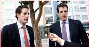 Two suited men on a city street being interviewed, a microphone held toward them by a person off-camera