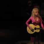 Dolly Parton performs onstage with her guitar at Wolf Trap in 2011.