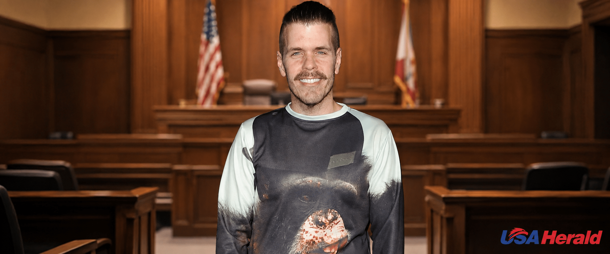 Smiling man stands in a courtroom with wooden panels and a flag behind him.