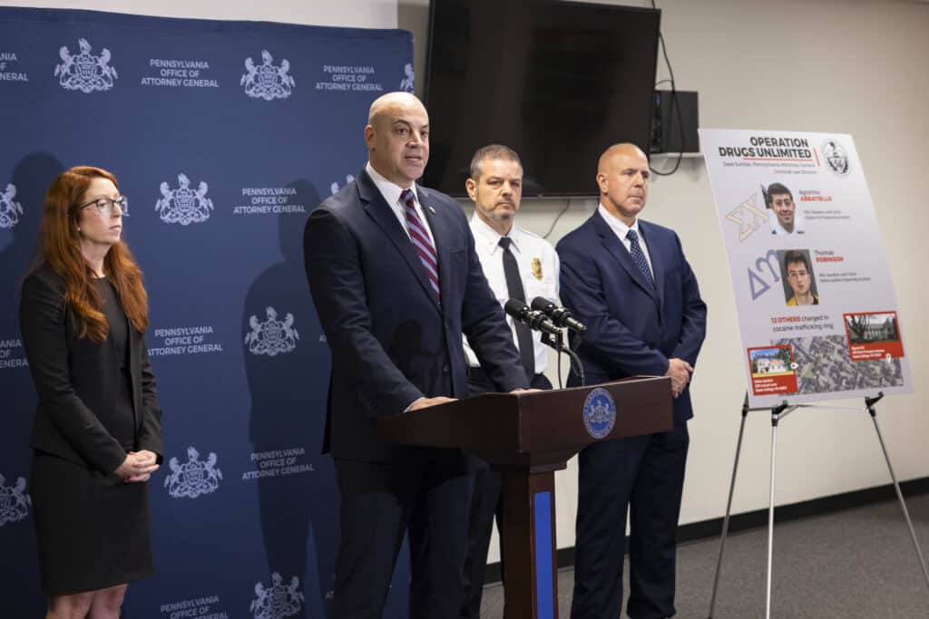 Pennsylvania Attorney General Dave Sunday speaks beside a board displaying details about the alleged Penn State cocaine ring.