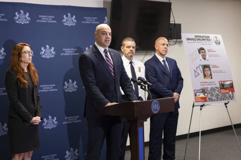 Pennsylvania Attorney General Dave Sunday speaks beside a board displaying details about the alleged Penn State cocaine ring.