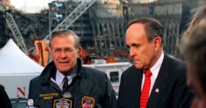 Rudy Giuliani and Donald Rumsfeld address reporters amid the wreckage at Ground Zero.