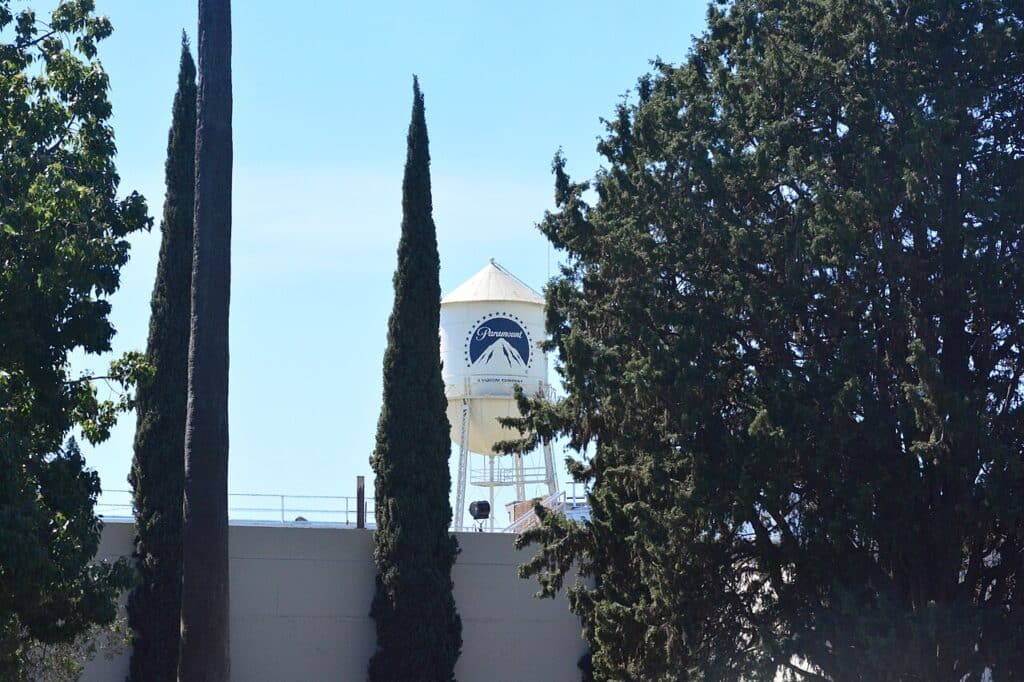 Paramount Pictures logo on a white water tower framed by trees in Los Angeles.