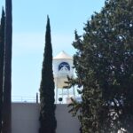 Paramount Pictures logo on a white water tower framed by trees in Los Angeles.