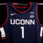 Here is an article about a lawsuit. Use the main keyword:NJM Insurance and UConn Huskies Partnership. Rewrite and Do not omit any important information in the rewriting, keep the same length and write in news voice AP style. Turn this into a news article, and make it thrilling to keep the reader hooked from start to finish. Use analogies and perplexity and burstiness. Do not use exact matching sentences but alter them creatively. Use H2 and H3 headings where appropriate. Give a 100 characters meta description using the main keyword. Give tags separated by commas , add USA , and USA Herald to the tags. Use english language only