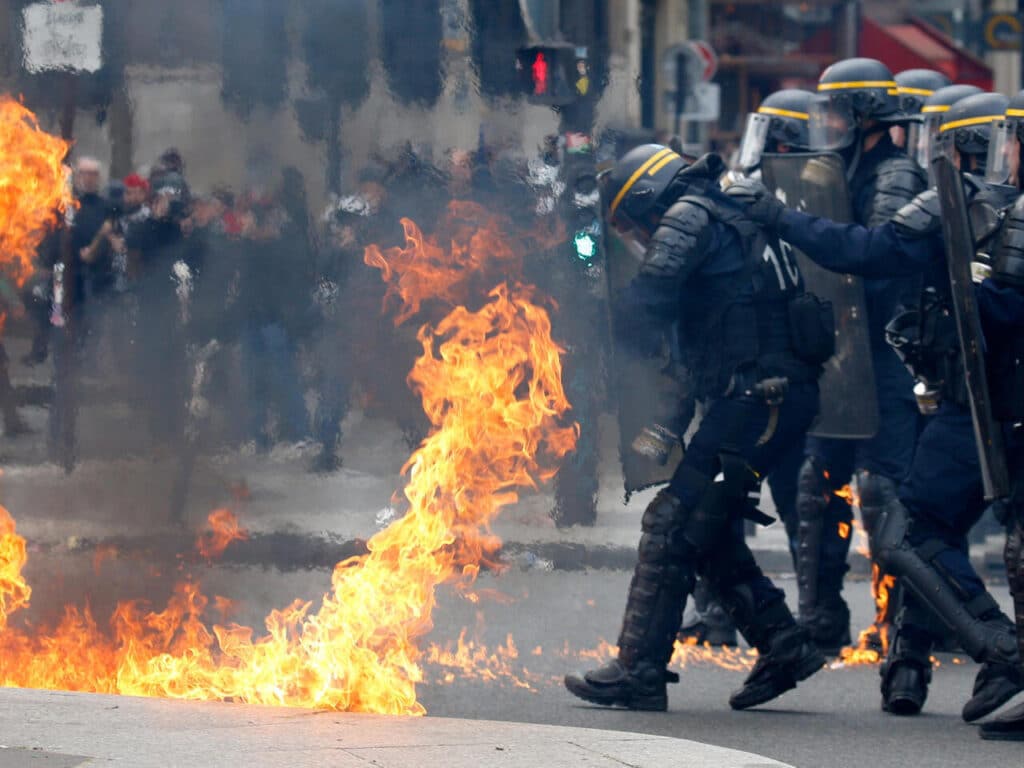 French CRS riot police protect themselves from flames during clashes at the traditional May Day labour union march in Paris