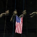 Military spectacle at the Alamodome, with soldiers rappelling beside an American flag during a previous pregame ceremony.