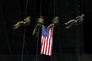 Military spectacle at the Alamodome, with soldiers rappelling beside an American flag during a previous pregame ceremony.