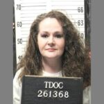 Christa Pike holding a Tennessee Department of Correction identification board.