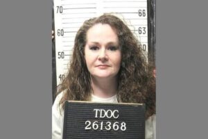 Christa Pike holding a Tennessee Department of Correction identification board.