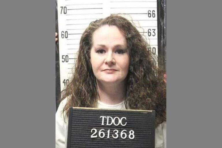 Christa Pike holding a Tennessee Department of Correction identification board.